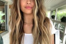long dark brunette hair with gold blonde highlights and a money piece, with much volume is a beautiful beachy idea