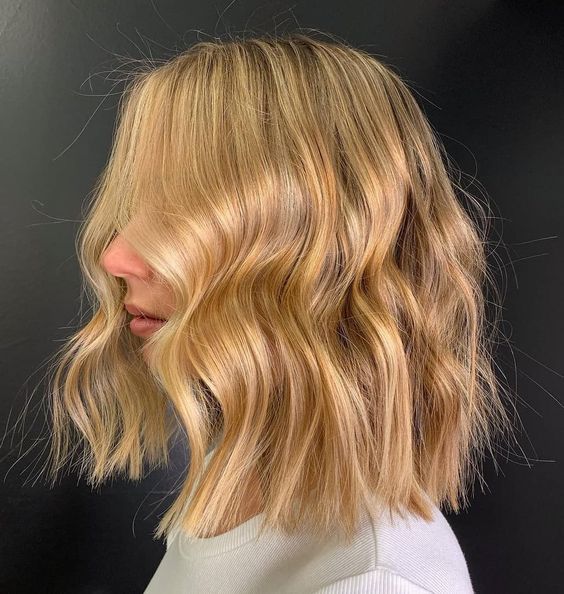 Lovely gold blonde shoulder length hair with waves and texture looks unbelievably chic and catchy