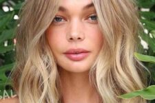 medium length honey blonde hair with beach balayage and messy waves is a cool idea for a summer feel