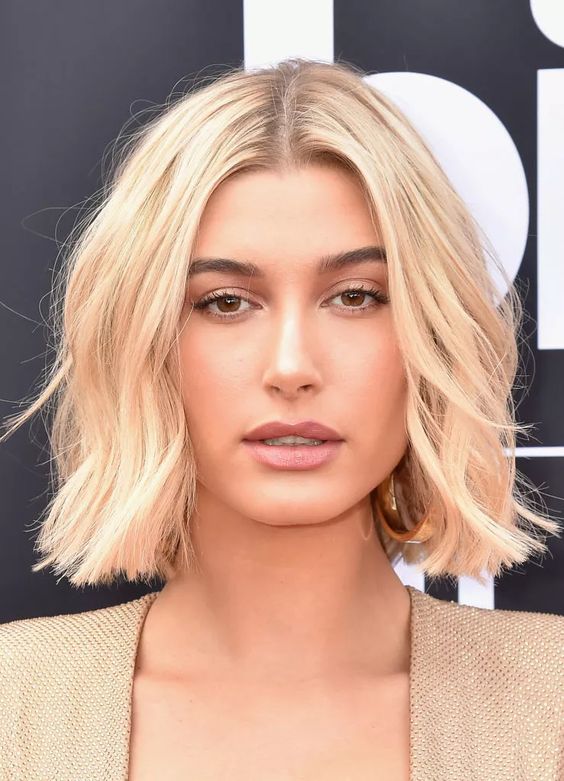 Hailey Bieber wearing a wavy blonde midi bob with central parting looks gorgeous and super chic