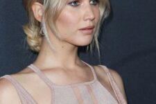 Jennifer Lawrence wearing a low blonde bun and face-framing layers plus middle part looks fabulous