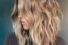 a beautiful beach bronde shaggy haircut with beach waves and central part looks very lovely and relaxed