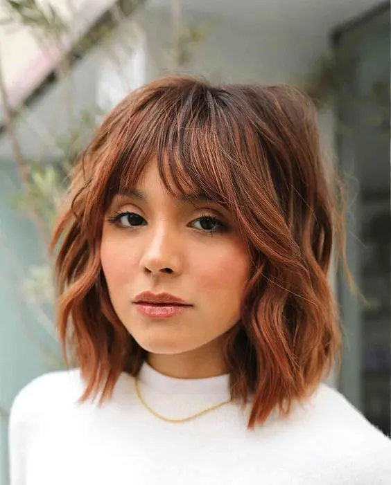 a beautiful copper shaggy long bob with a darker brown root and choppy layers is amazing to try for the fall