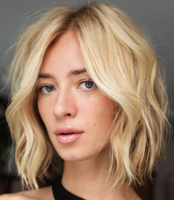 a beautiful textural blonde medium bob with side part and shaggy layers is a bold and catchy solution