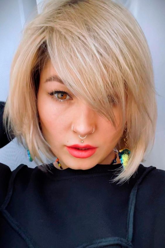 a chin-length creamy blonde bob with side bangs and plenty of movement and texture