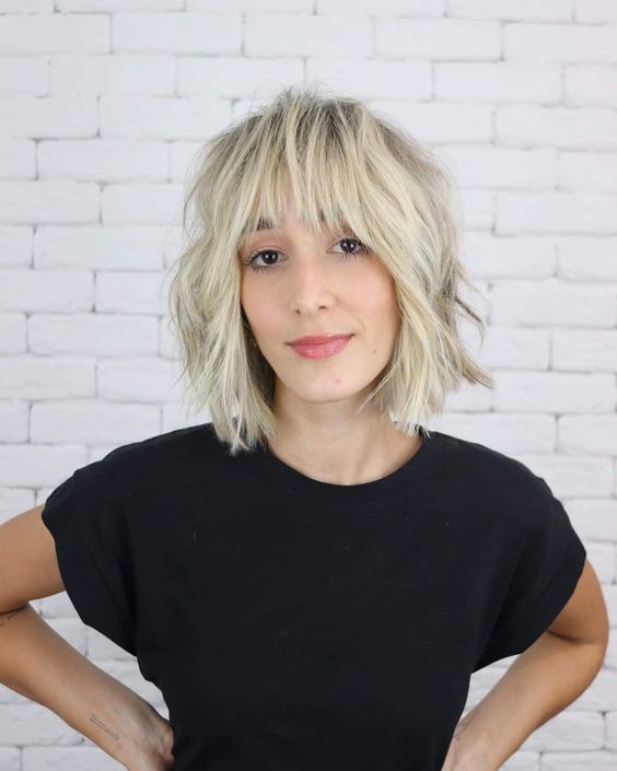 a cold blonde shaggy medium bob with a fringe and cool and lovely texture looks grunge-like