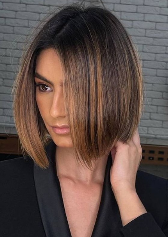 a dark brown bob with a darker root and caramel balayage is a chic and flattering idea to try right now