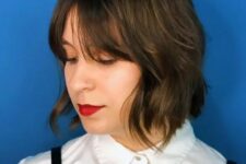 a dark brunette shaggy bob with Bardot bangs and a bit of highlights is a stylish and catchy idea