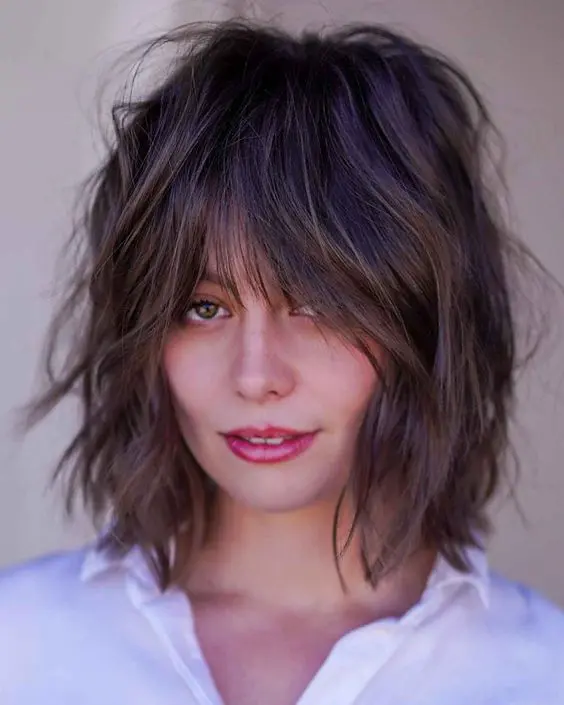 a dark brunette shaggy bob with wispy bangs and a lot of dimension is a cool and lovely idea to rock