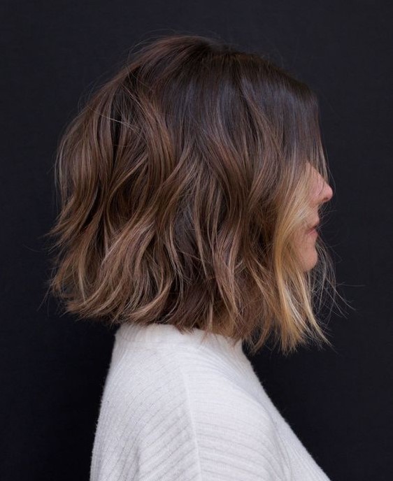 a gorgeous dark brown bob with a black root, chestnut balayage and blonde money piece to highlight the look