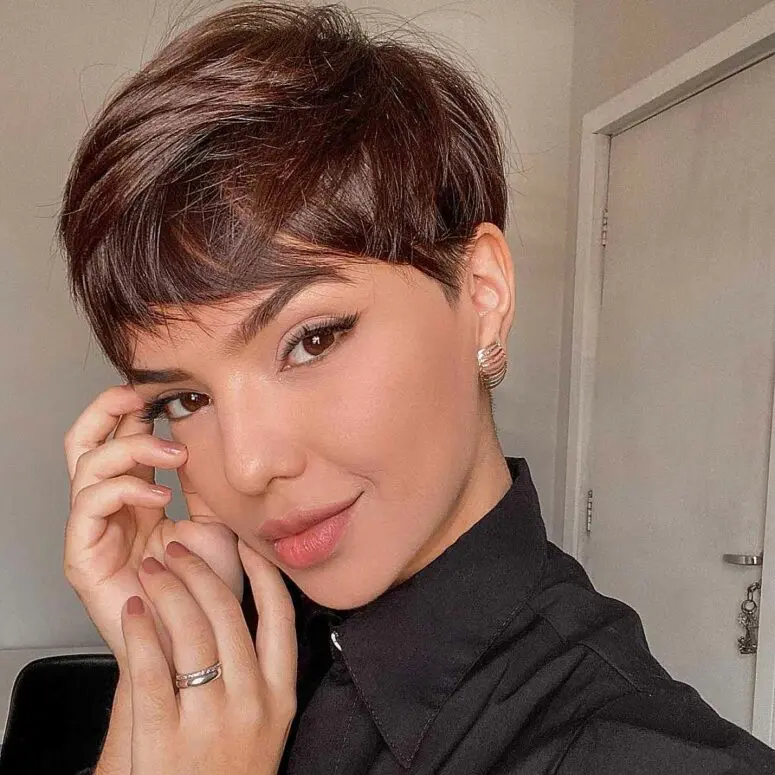 a layered pixie haircut in a rich brown shade, with soft layers that create movement plus a long fringe to accent the eyes