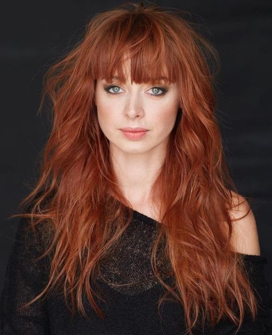 a long layered copper haircut with fringe bangs and a texture to make a statement