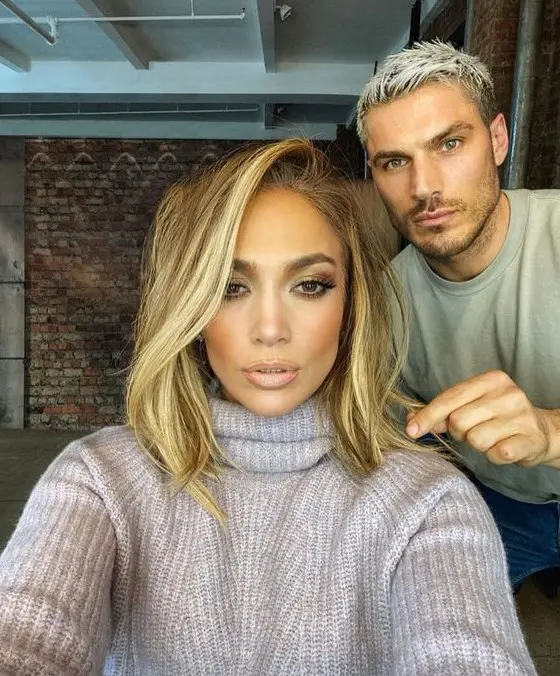 a long shaggy bob with blonde balayage and a long side fringe by J.Lo