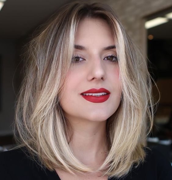 A pretty blonde medium length haircut with a darker root and face framing layers is a very cool low maintenance idea