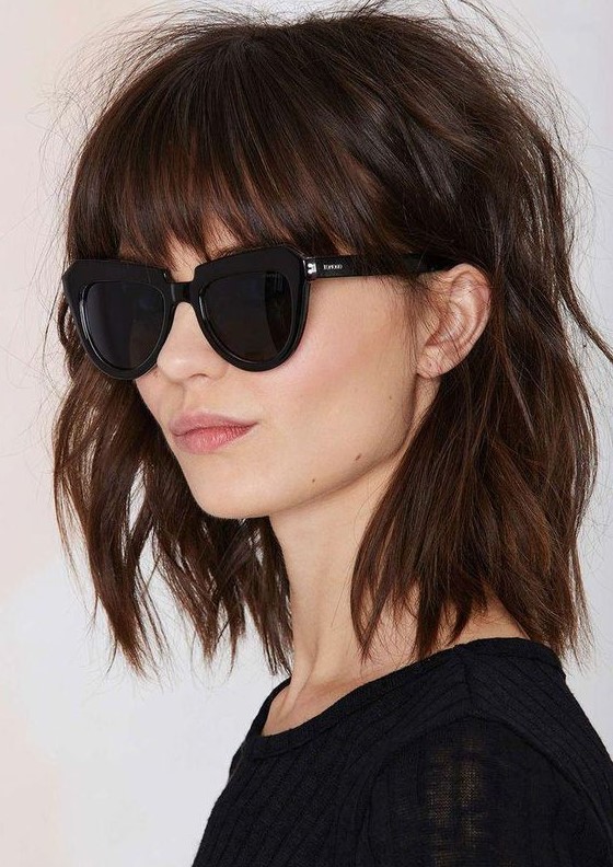 A shaggy brown shoulder length bob with classic bangs and messy waves is a very rock n roll idea to rock
