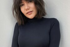 a shaggy dark brunette bob with curtain Bardot bangs and a lot of texture is amazing to wear now