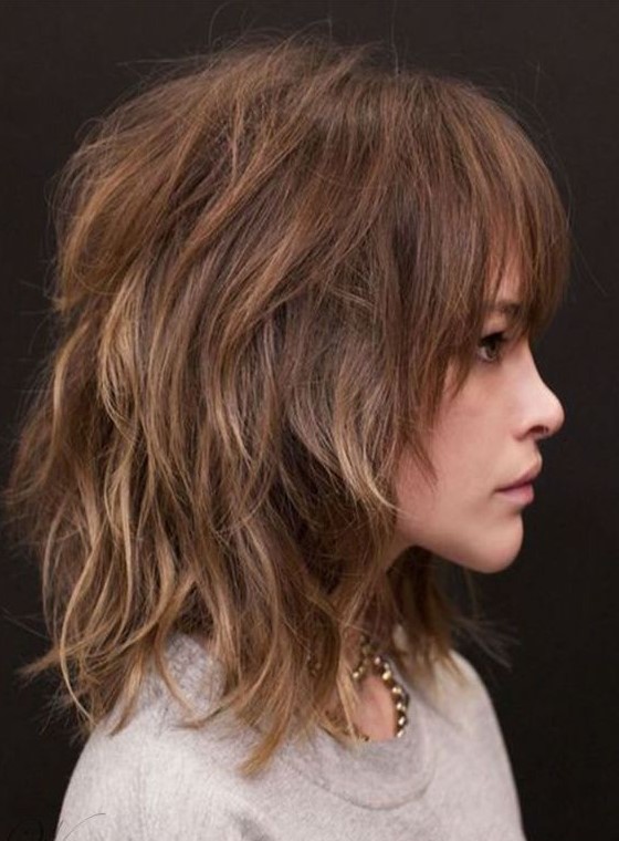 a shoulder-length layered shaggy haircut with blonde highlights and overgrown bangs is a bold and cool idea