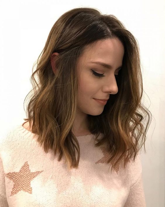 a soft brown medium-length haircut with caramel balayage and waves is a very chic and relaxed idea