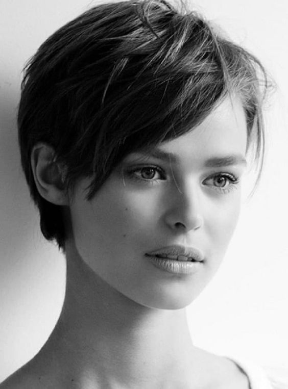 a textured layered pixie on thick hair, with longer side bangs, is a very cool and chic idea to try right now