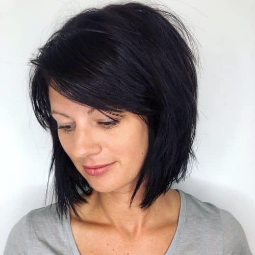 a textured stacked bob in black with side bangs is a cool idea, adn tapered layers help to frame the face
