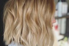 a wavy gold blonde long bob with a darker root is an effortlessly chic idea to go for, it looks nice and cool