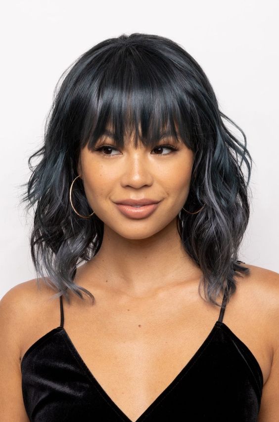 black wavy hair with an ombre touch and fringe bangs is a very chic and cool idea to rock
