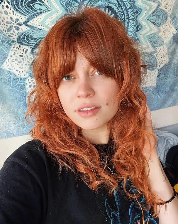 Bold curly ginger hair with Bardot curtain bangs is a beautiful fall inspired idea to try