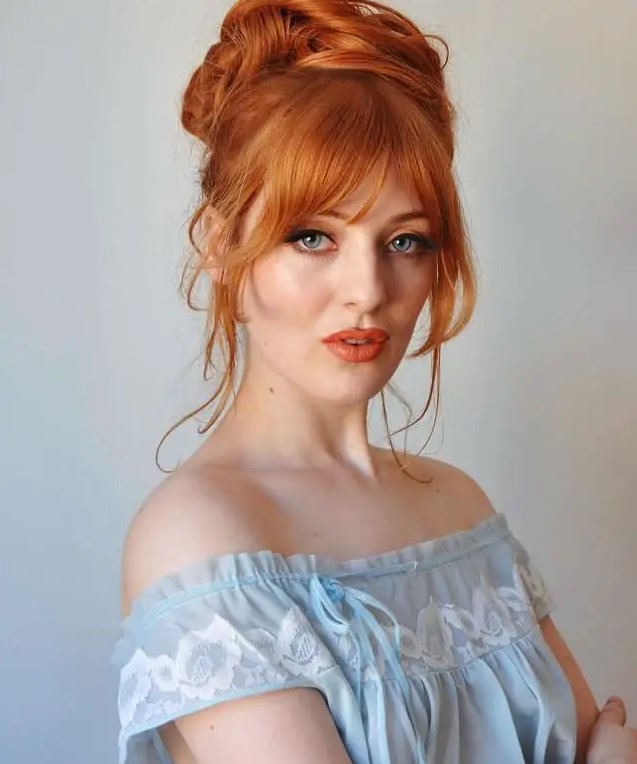 bright ginger hair in a top knot, with some face-framing hair and lovely Bardot bangs looks jaw-dropping