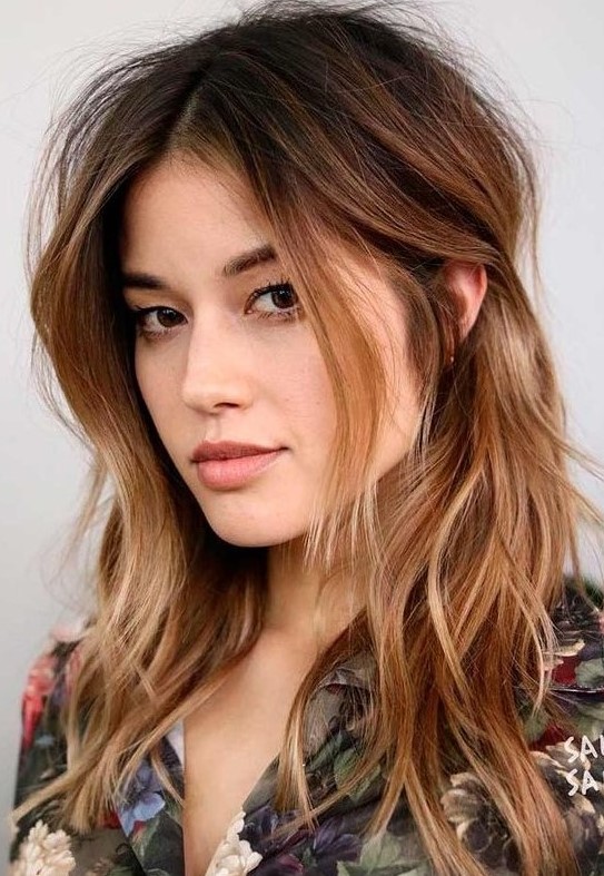 dark brown root plus ombre caramel ends and messy waves plus layers around the face looks bold and catchy