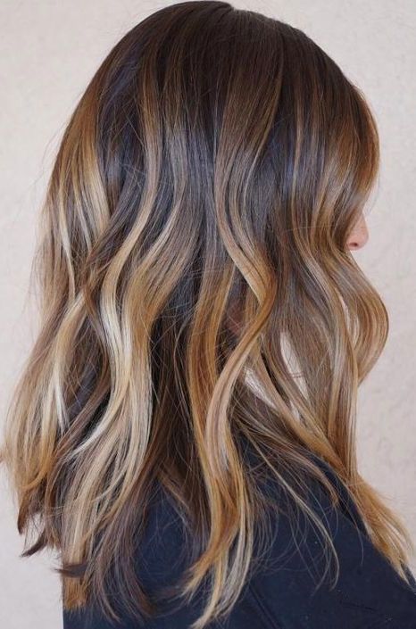 dark brunette hair with a caramel balayage and blonde balayage plus beach waves is a very chic and cool idea