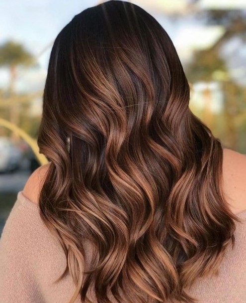 dark brunette hair with waves and gorgeous caramel balayage is a bold and cool idea to rock, it looks dimensional
