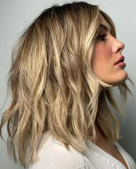 gorgeous golden blonde choppy and layered hair with a darker root and a bit of texture looks cool