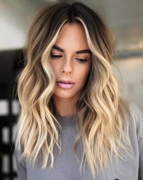 long brown hair with bright blonde balayage and a money piece plus beachy waves is a very lovely solution