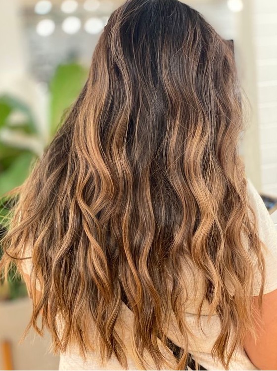 Long, dark brunette hair with caramel and bronde balayage and beach waves is a great idea for a beach inspired look