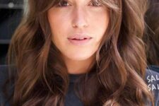 long wavy brown hair cut in layers and with a Bardot fringe is a lovely idea that feels a bit rock-style