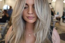 lovely long blonde hair done in a cold shade, with face-framing layers and central part to accent the face
