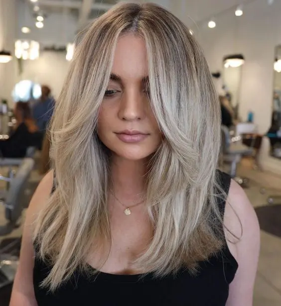 lovely long blonde hair done in a cold shade, with face-framing layers and central part to accent the face