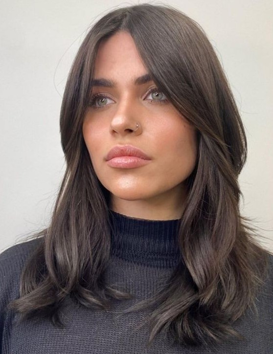 Medium length dark brown hair with face framing layers and waves, middle part looks very stylish and beautiful