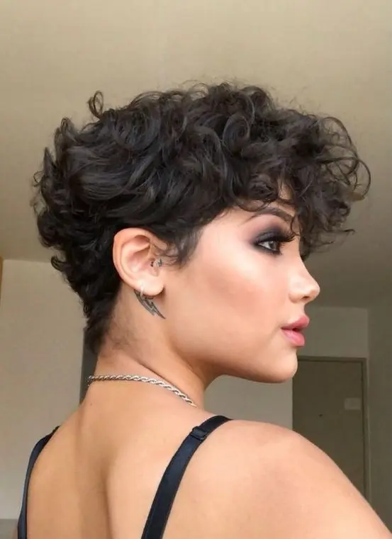 A bold black wavy pixie with a lot of volume and longer bangs is a very beautiful and eye catching idea to try