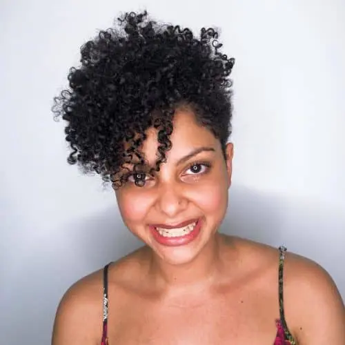 a short curly haircut with long curly bangs is a bold and cool idea with a lot of volume