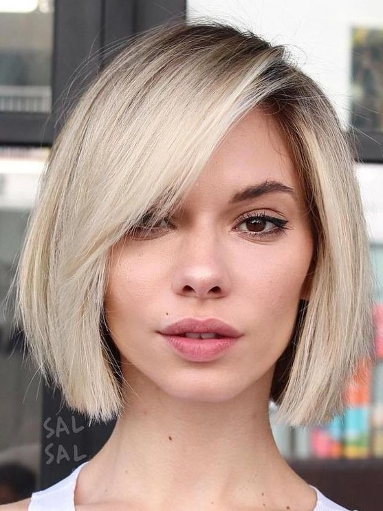 a cool blonde midi bob with side bangs and a darker root is a very stylish and catchy idea for anyone