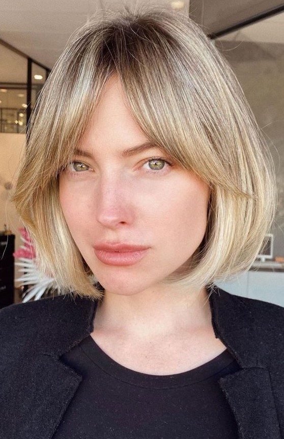 A lovely blonde bob with a darker root and soft curtain bangs is a very up to date idea to try