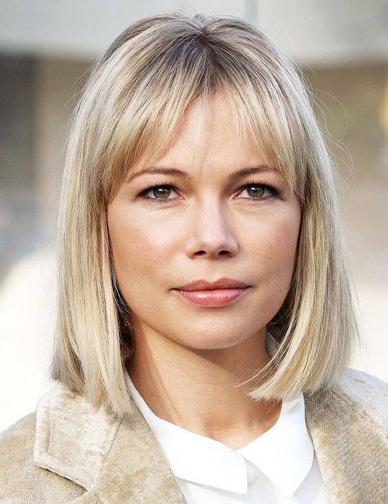 Michelle Williams rocking a long blonde bob with wispy bangs looks very stylish, classic and timeless