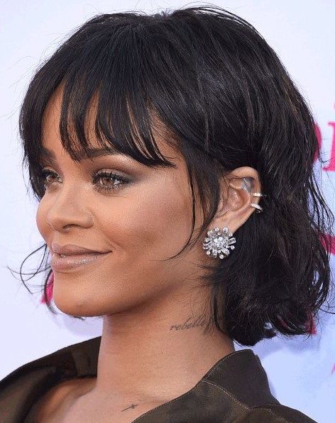 Rihanna rocking a black chin length bob with messy waves and wispy bottleneck bangs looks jaw dropping