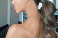a beautiful and elegant wavy low ponytail with a sleek and shiny top is a stylsih idea for a glam girl