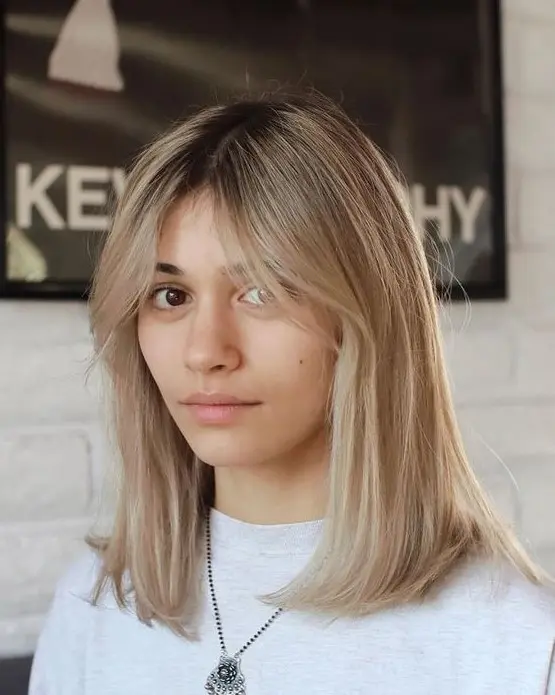 a beautiful and relaxed blonde shade with a darker root, curtain bangs is a pretty idea to rock right now