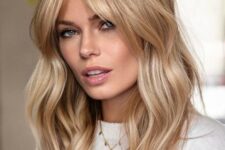 a beautiful long hairstyle with waves, a darker root and soft wavy curtain bangs that accent the face