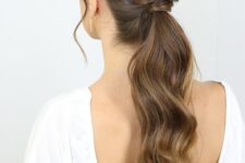 a beautiful low ponytail with waves and a twisted touch plus face-framing hair is a chic idea
