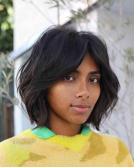 a black dimensional bob with bottleneck bangs and textured hair is a cic and cool idea to rock