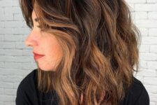 a black medium-length haircut with caramel balayage and waves, with side bangs is a catchy and very chic idea